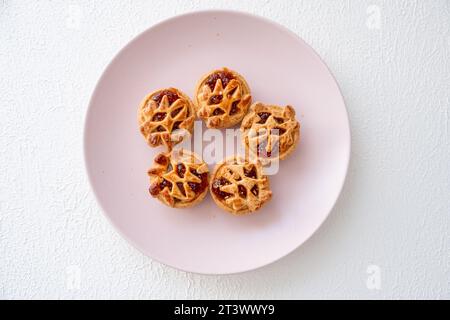 tiny apple pies on pink plate in macro shot Stock Photo