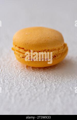 orange macaroon on white background in close-up Stock Photo