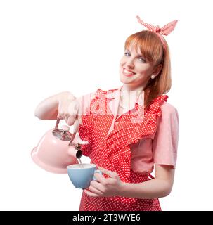Cheerful beautiful traditional housewife pouring hot water in a cup and smiling Stock Photo