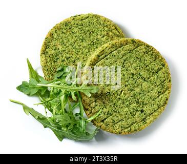 baked plant based vegan burger patty isolated on white background decorated with fresh arugula, top view Stock Photo