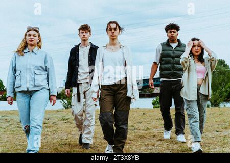 Full length portrait of confident young friends walking against sky Stock Photo