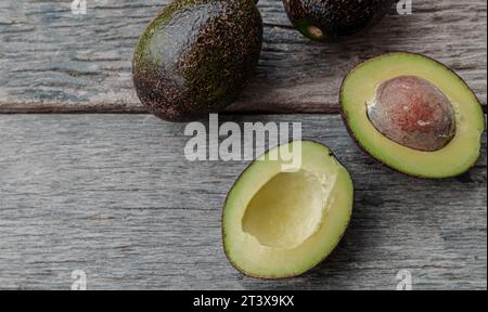 Avocado cut in half on an old wooden table Stock Photo