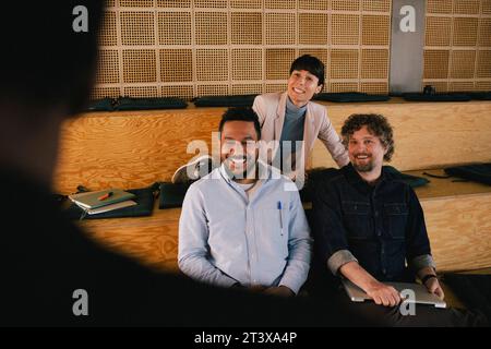Happy colleagues looking at businesswoman in office during meeting Stock Photo