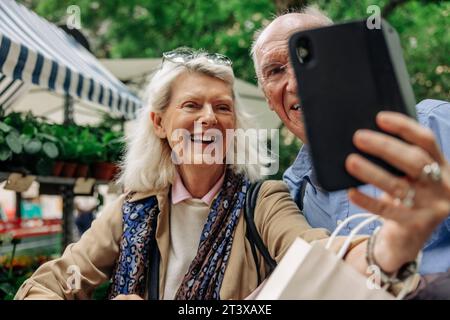 Happy senior woman taking selfie with man through smart phone Stock Photo