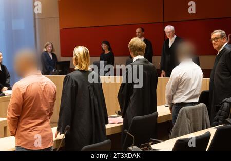 27 October 2023, North Rhine-Westphalia, Bochum: The accused construction workers (l and 2nd from right) stand before Judge Josef Große Feldhaus (3rd from right) before the pronouncement of the verdict in the trial on the devastating gas explosion in Bochum in the Regional Court. Almost ten months after the gas explosion, the construction worker has been sentenced to two and a half years in prison. The 51-year-old defendant was part of a construction crew that had drilled into a gas pipeline during fiber optic work on January 10 of this year. Photo: Dieter Menne/dpa - ATTENTION: Persons have b Stock Photo