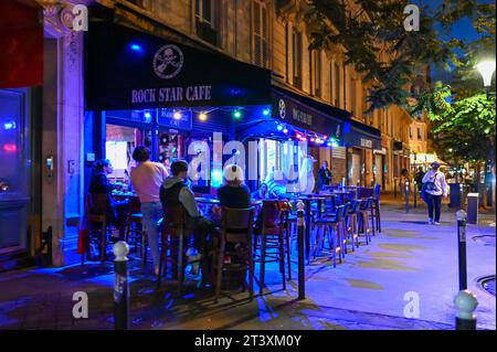 Paris, France, June 2022. Fascinating night shot of one of the many cafes that we can see along the streets of the center. People sitting at tables en Stock Photo