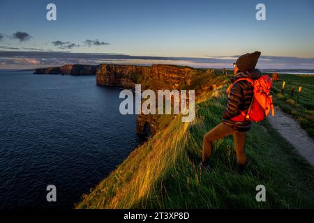 Cliffs of Moher, cliffside hiker, The Burren, County Clare, Ireland, United Kingdom. Stock Photo