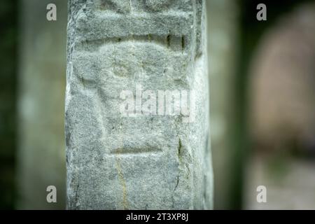 carved head in low relief with protruding ears, Kilfenora Medieval Cathedral (Saint Fachtnanrsquo), Doorty Cross, The Burren, County Clare, Ireland, United Kingdom. Stock Photo