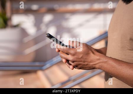 close up of young black using smartphone app outdoors. Stock Photo