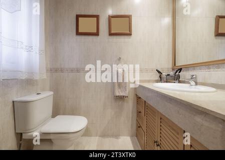 Bathroom tiled with cream-colored marble-like tiles, Stock Photo