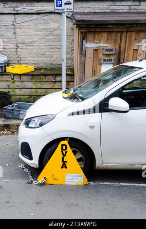 A car with a clamp on its front wheel parked in Newquay in Cornwall in the UK.