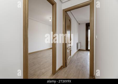 Hallway distributor of residence housing with oak wood carpentry on doors and moldings and light-colored flooring on the floor Stock Photo