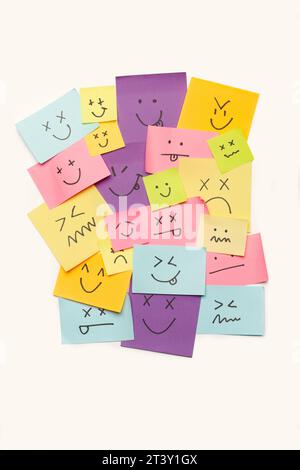 Colored paper notes with drawings of different face emotions on a white background Stock Photo