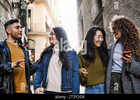 Diverse group of people having fun in city street. Multiracial tourist friends enjoy holiday during winter time Stock Photo
