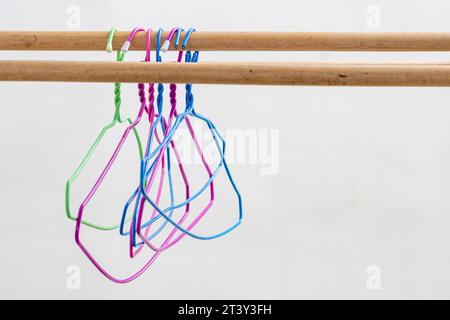 Plastic hangers hang on a wooden bar Stock Photo