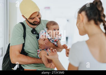 Parents having fun with their baby while waiting for medical checkups at the hospital. Young parents playing their baby before medical examinations. Stock Photo