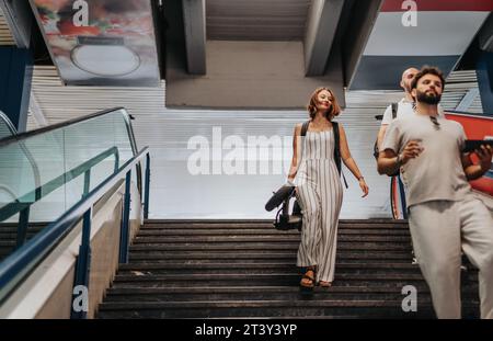 Adult professionals collaborating on a new project, discussing market research and marketing strategies, in a modern office with a staircase backdrop. Stock Photo