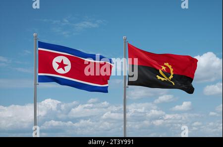 North Korea and Angola flags waving together in the wind on blue cloudy sky Stock Photo