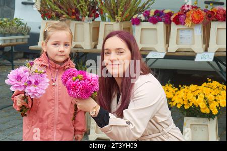 Mother and daughter buying fresh flowers at a farmers market in the center of Prague Stock Photo