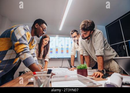Multiracial Team of Architects and Engineers Collaborating on Innovative Project in Board Room Stock Photo