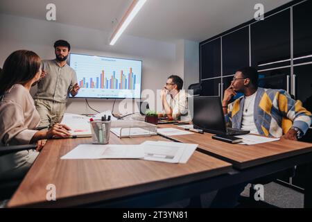 Diverse professionals brainstorm together in a modern boardroom, collaborating on projects, discussing ideas, and developing a sales strategy. Stock Photo