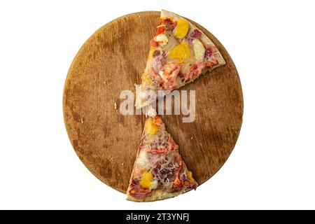 two slices of pizza on a round wooden board on a white background Stock Photo