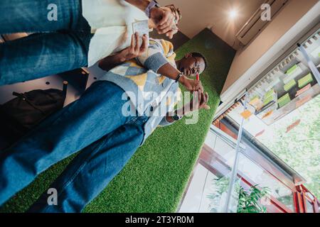 Diverse colleagues brainstorm and collaborate, sharing ideas on sticky notes. Multiracial team in a modern office, focused on teamwork and innovation. Stock Photo