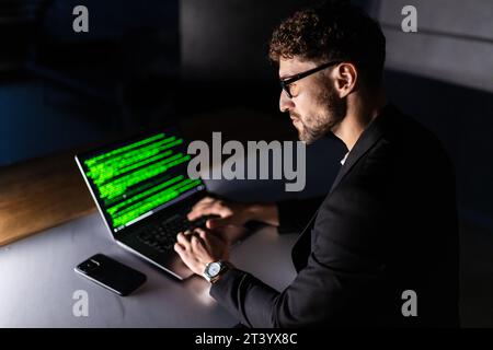 Young man mobile developer writes program code on a computer, programmer work in home office. Stock Photo