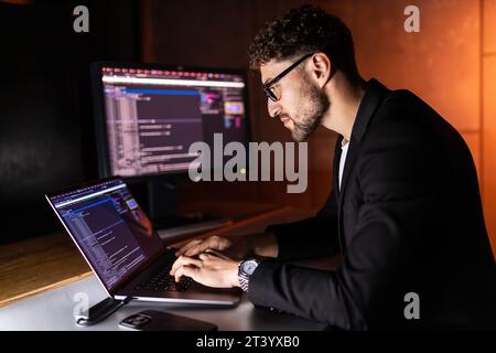 Handsome young programmer working at home late in evening Stock Photo