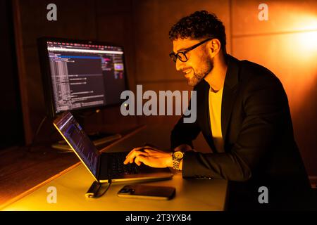 Handsome young programmer working at home late in evening Stock Photo