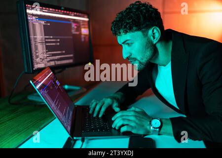 Handsome young programmer working at home late in evening Stock Photo