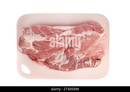 Top view of raw pork meat on a plastic cutting board. White background, copy space. Stock Photo