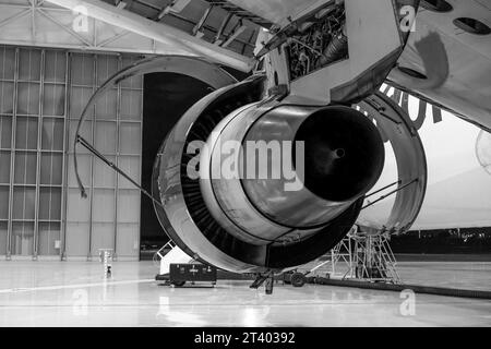 Airplane repairing in the hangar. Aircraft engine on the wing. Maintenance. Black and white photo. Stock Photo