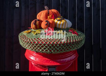 Halloween decorations, pumpkins, yarn bombing on red post box postbox letterbox letterbox, October 2023, UK Stock Photo