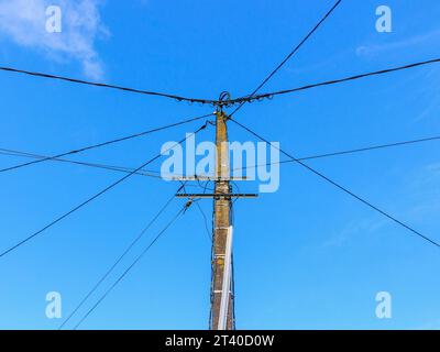 Concrete telegraph post supporting wires and cables for electricity, telephone and fibre connections - Bossay-sur-Claise, Indre-et-Loire (37), France. Stock Photo
