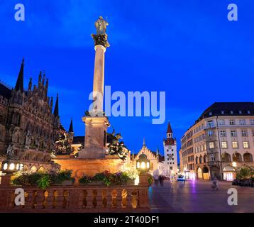 View on the main town hall with clock tower on Mary's Square illuminated at dusk with the Old City Hall on the background in Munich, Germany Stock Photo