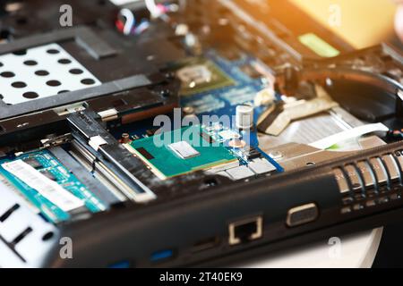 Fixing laptop. Repairman holds cooling fan and repairs from overheating. Disassembling computer, replacement, clean dust and dirt cooling system on no Stock Photo