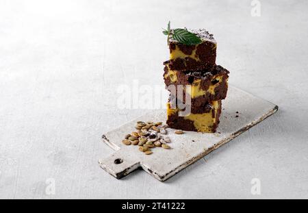 Pumpkin chocolate brownie on white background. Thanksgiving day food. Side view, close up. Bakery, confectionery, menu concept Stock Photo