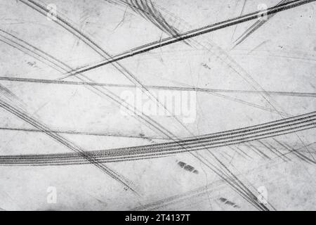 Textured background of vehicle traces on road from scooter, bike, bicycle weel. Tire print texture of transport Stock Photo