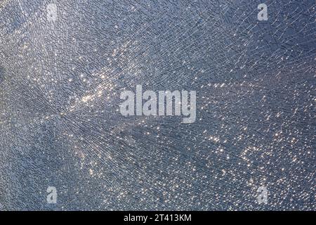 cracks at tempered glass, spoiled glass surface, texture background, blind windscreen close-up, nobody. Stock Photo