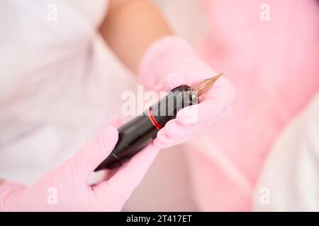 Stylish device for permanent makeup in the hands of master Stock Photo