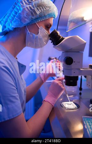 Experienced embryologist preparing specimen for microscopic examination Stock Photo