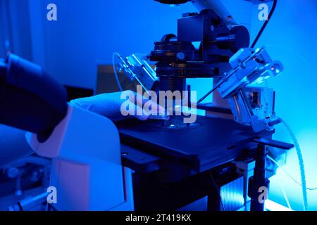 Lab scientist preparing for cell manipulation with micromanipulator Stock Photo