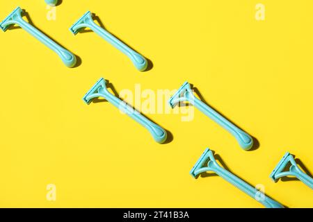 Many safety razors on yellow background Stock Photo