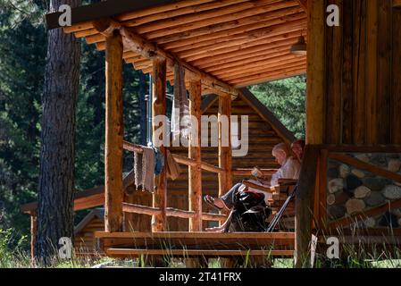 Couple relaxing on the porch of a cabin at the Minam River Lodge, Oregon. Stock Photo