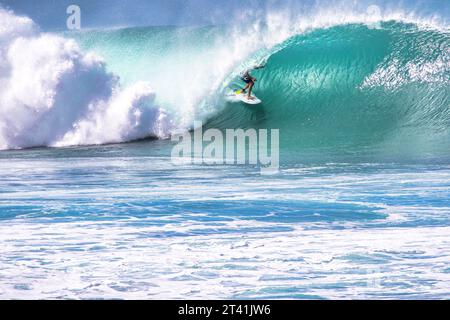 Unrecognizable surfer hidden in the curl of a large wave on North shore hawaii. Stock Photo