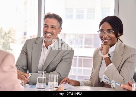 Happy busy diverse executive business people communicating at office meeting. Stock Photo