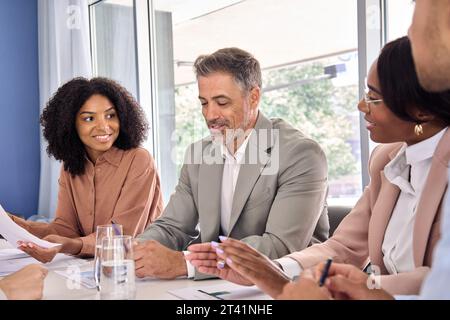 Happy busy diverse executive team having conversation during company meeting. Stock Photo