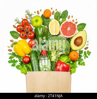 a set of healthy food in full paper bag of different products. Raw vegetables and bottle of water Stock Photo