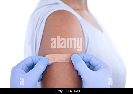 Plaster being applied to woman's arm Stock Photo